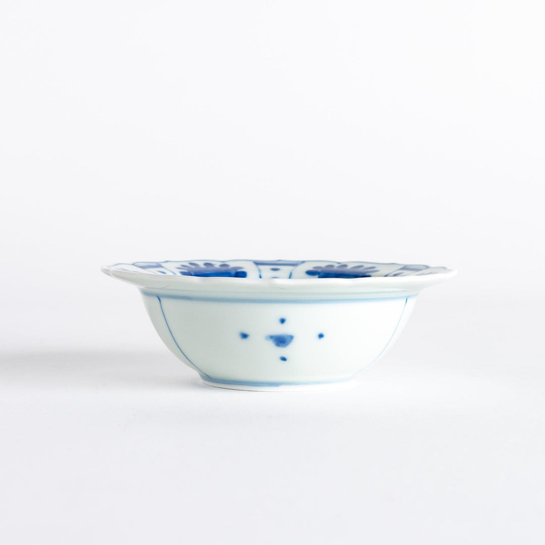 A dessert bowl with a scalloped edge, decorated in blue with pastoral scenes of deer and landscape motifs.