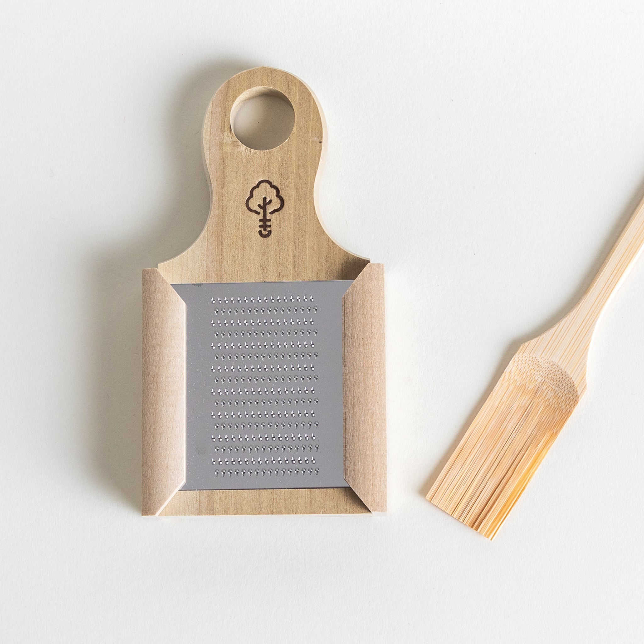 A set of Japanese wooden kitchen ware featuring a grater and a paddle.